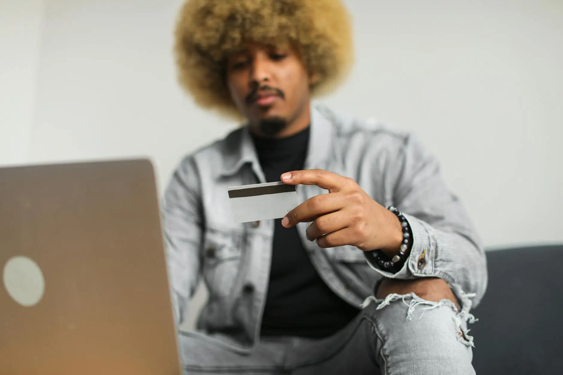 a man with an afro hair holding a credit card