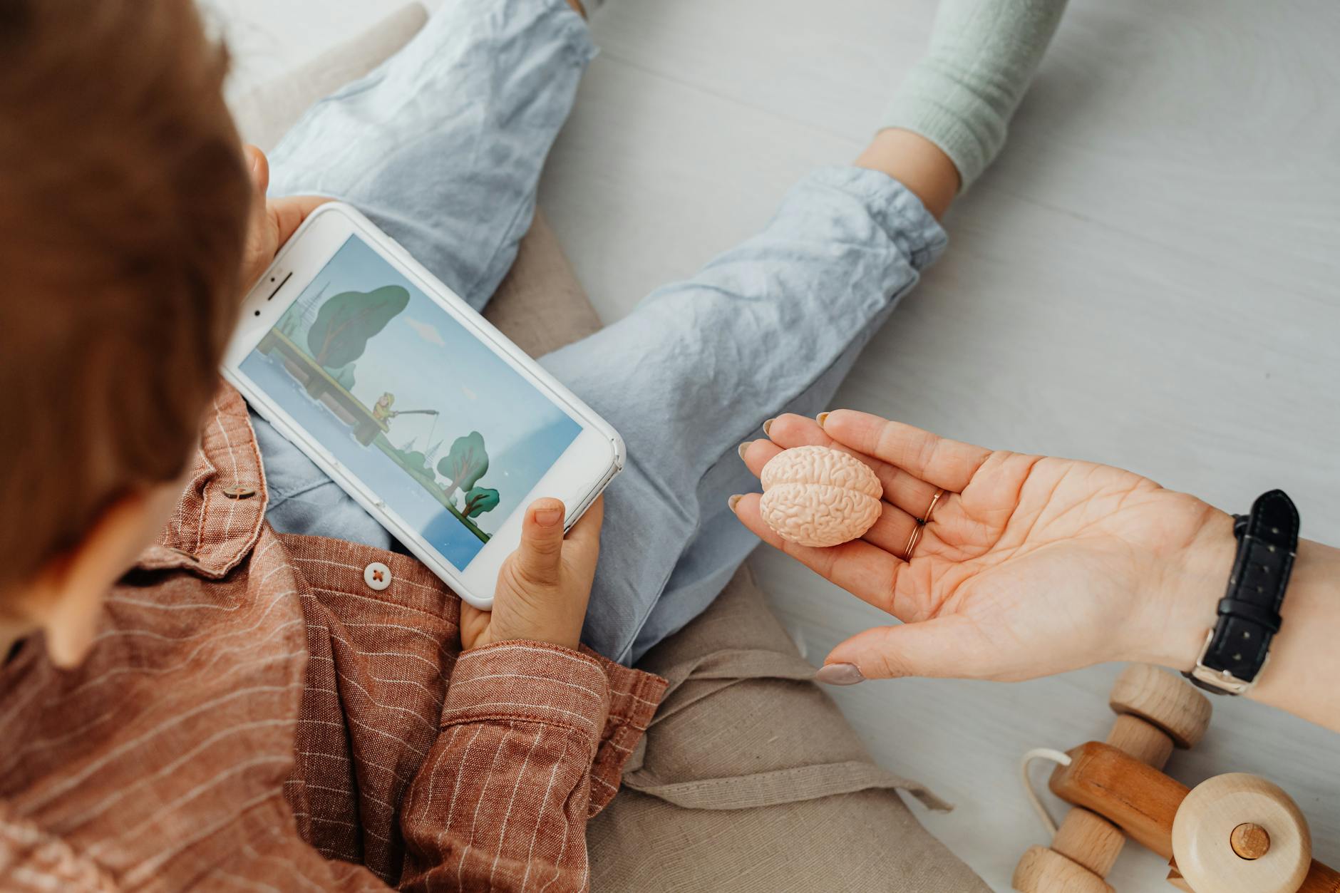 a person s hand near a kid holding a smartphone